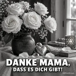 Weiße Rosen in einer dunklen Vase, ein Schmuckherz und ein Buch begleiten "Danke Mama, dass es dich gibt!" in Schwarz-Weiß.