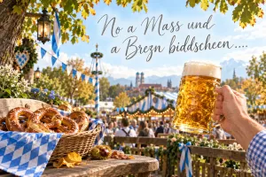 Eine Hand hebt einen Bierkrug neben einem Brezelkorb vor der Festkulisse: "No a Maß und a Brezn biddscheen....".