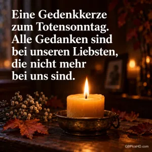 Eine brennende Stumpenkerze in einer Messingschale auf einem Holztisch mit Herbstlaub und Trockenblumen in dunklem Raum, dazu ein Gedenktext zum Totensonntag