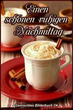 Weiße Tasse mit schaumigem Getränk und Zimtstangen auf rotem Teller für einen ruhigen Nachmittag