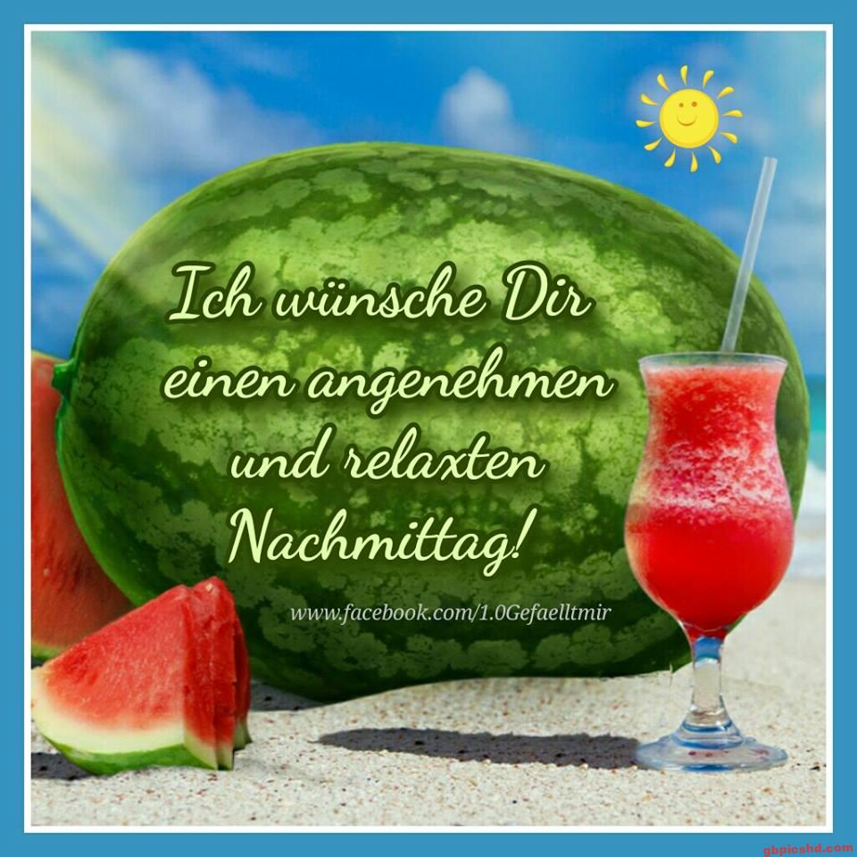 Große Wassermelone mit Melonenstücken und einem erfrischenden Getränk am Strand an einem sonnigen Nachmittag.