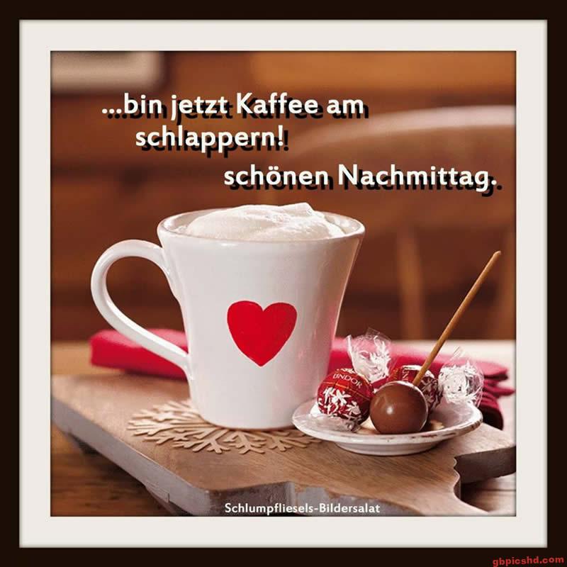 Weißer Kaffeebecher mit rotem Herz und Schokoladenpralinen auf Holzbrett für einen schönen Nachmittag.