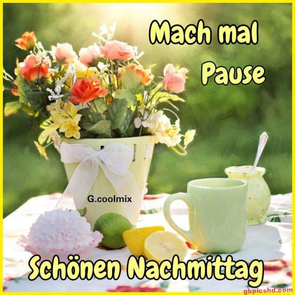 Blumenarrangement und Tasse auf einem Tisch mit der Grußbotschaft für einen schönen Nachmittag.