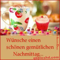 Bunte Tasse und roter Cupcake mit Süßigkeiten auf Tisch für einen gemütlichen Nachmittag.