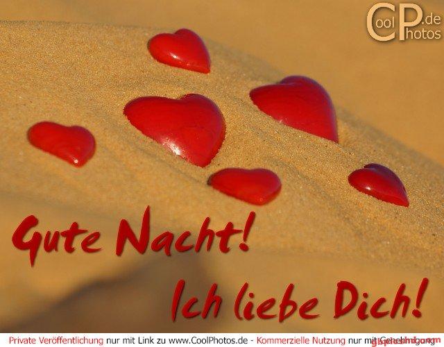 Mehrere rote Herzen auf Sand, symbolisch für Liebe und eine gute Nacht.