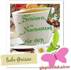 Weiße Tasse mit Blumendekoration und dem Wunsch für einen schönen Nachmittag.