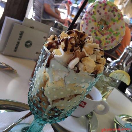 Getränk mit Sahne und Popcorn in einem blauen Glas im Café mit Zuckerring als Dekoration.