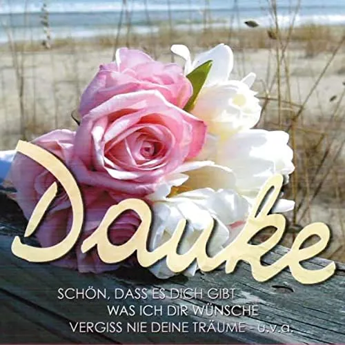 danke fur diesen guten morgen - Eine Blumenarrangement mit rosa und weißen Blumen auf sandigem Boden.