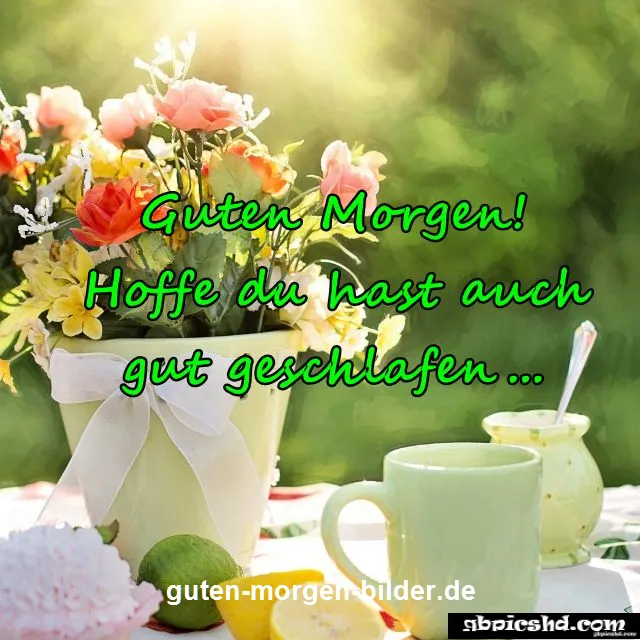 Vase mit bunten Blumen, Teetassen und Zitronen auf einem Tisch im Morgensonnenlicht.