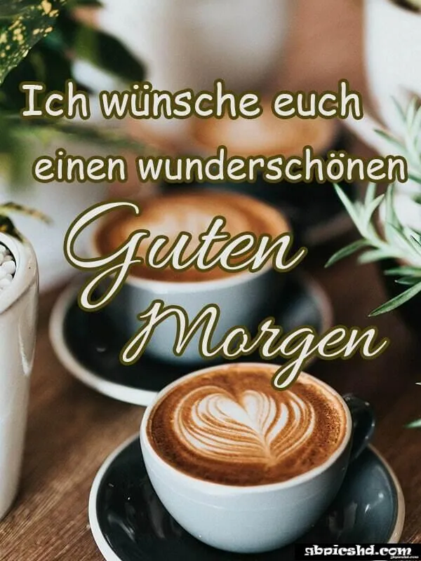 Zwei Kaffeetassen mit Herzmotiv und dem Text „Guten Morgen“. Pflanzen im Hintergrund sichtbar.