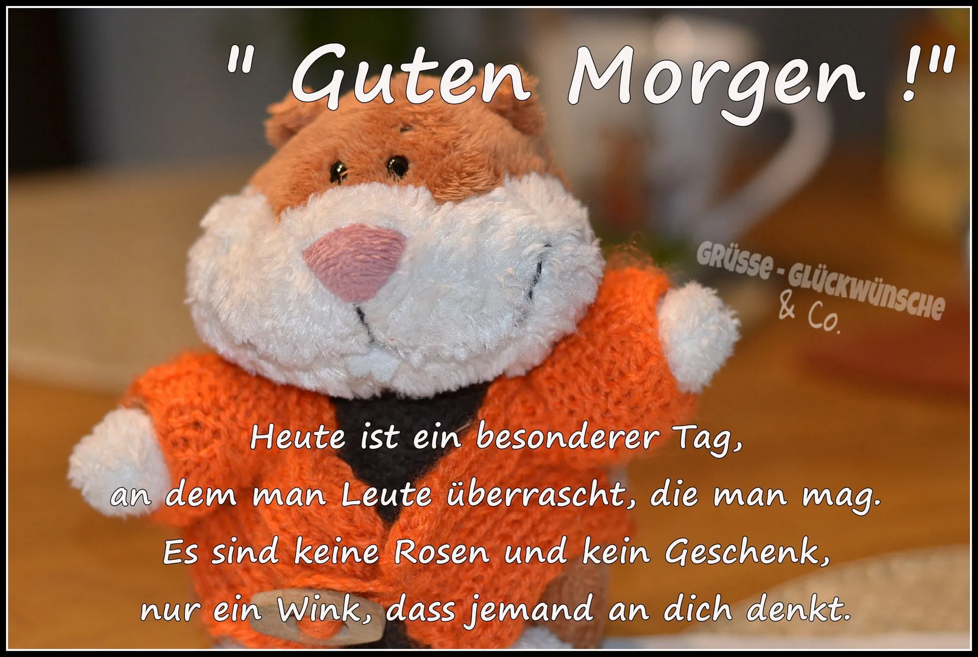 Ein Plüsch-Otter in orange mit einem Aufschrift "Guten Morgen!" auf einem Tisch.