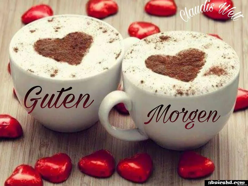 Zwei Kaffeetassen mit Herzmuster und roten Schokoladenherzen.