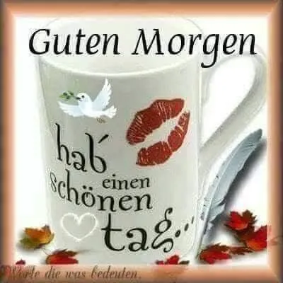 Beige Tasse mit Aufschrift "Guten Morgen" und roten Lippenabdrücken, umgeben von Herbstblättern.
