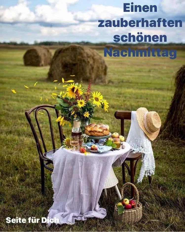Ein Tisch mit Blumen, Früchten, Gebäck und einem Getränk in einer ländlichen Landschaft.