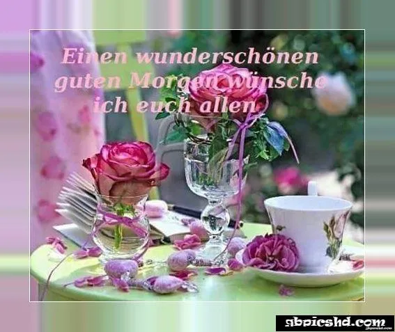 Zwei Rosen in einem Glas, eine Tasse auf einem Tisch mit einer Morgenbotschaft.