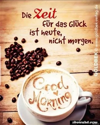 Eine Tasse Kaffee mit "Good Morning" und Kaffeebohnen auf einem Tisch.